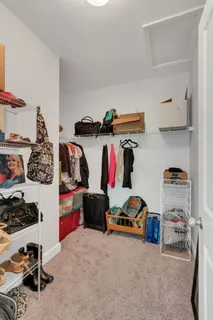 a view of walk in closet with clothes and shoes