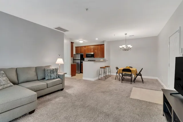 a living room with furniture and kitchen view