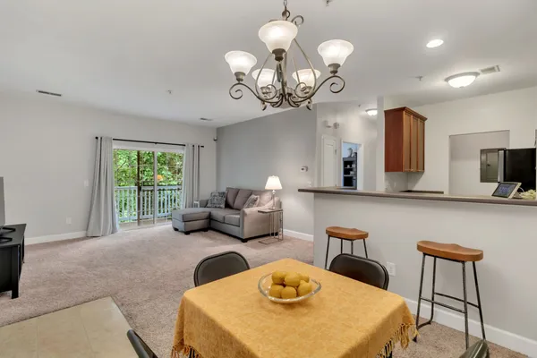 a living room with furniture a chandelier and a large mirror