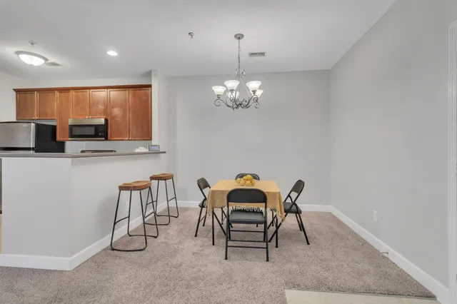 a view of a dining room with furniture and chandelier