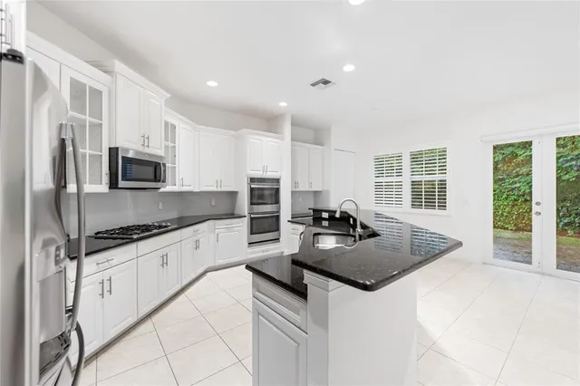 a kitchen with granite countertop a sink stove and refrigerator