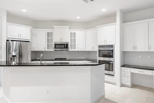 a kitchen with stainless steel appliances granite countertop a sink and cabinets