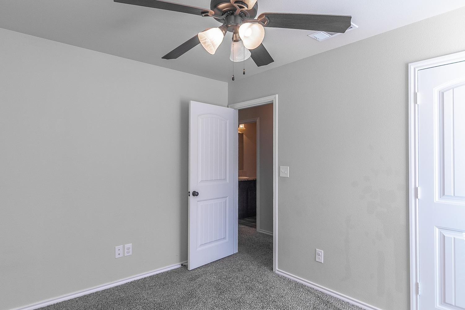 7449 104th Street Lubbock, TX 79424 - Photo 12 of 16 an empty room with a ceiling fan and a ceiling fan