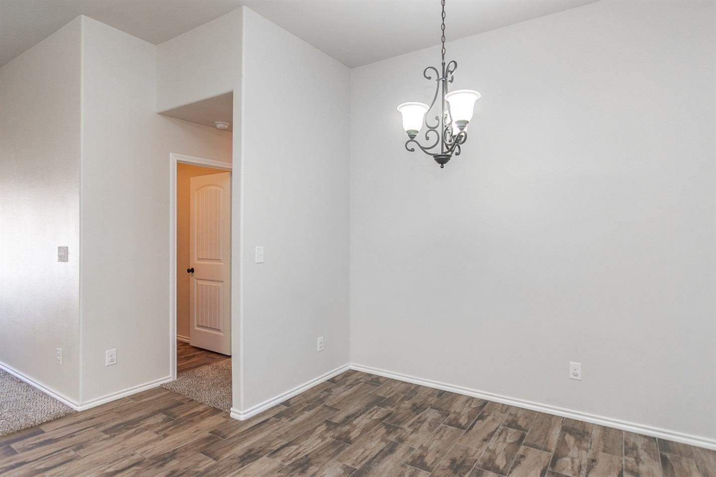 7449 104th Street Lubbock, TX 79424 - Photo 4 of 16 a view of a chandelier in big room and wooden floor