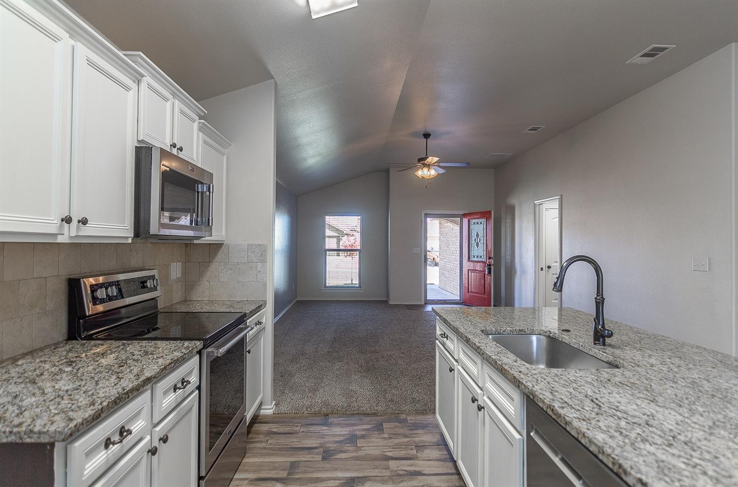 7449 104th Street Lubbock, TX 79424 - Photo 5 of 16 a kitchen with stainless steel appliances granite countertop a sink stove and cabinets
