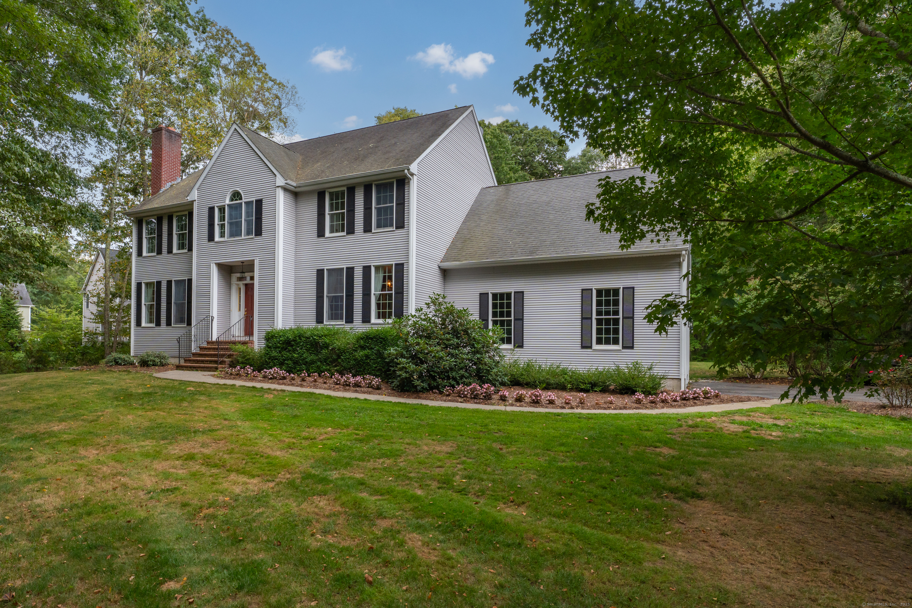 a front view of a house with a garden and yard