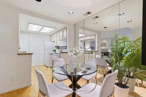 a dining room with furniture potted plants and wooden floor