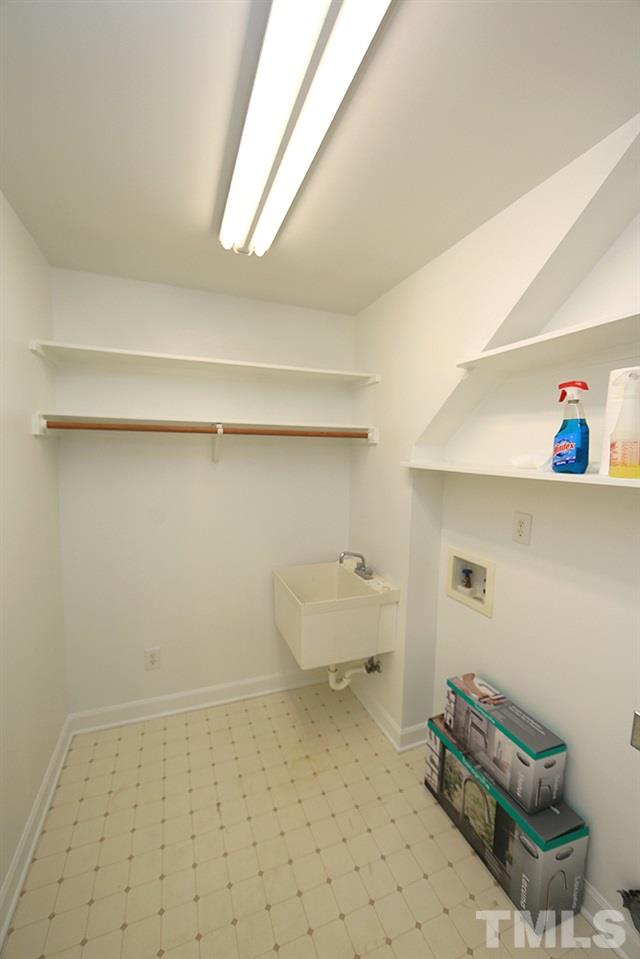 4428 Touchstone Forest Road Raleigh, NC 27612 - Photo 9 of 21 Separate laundry room with stationary tub and shelving.