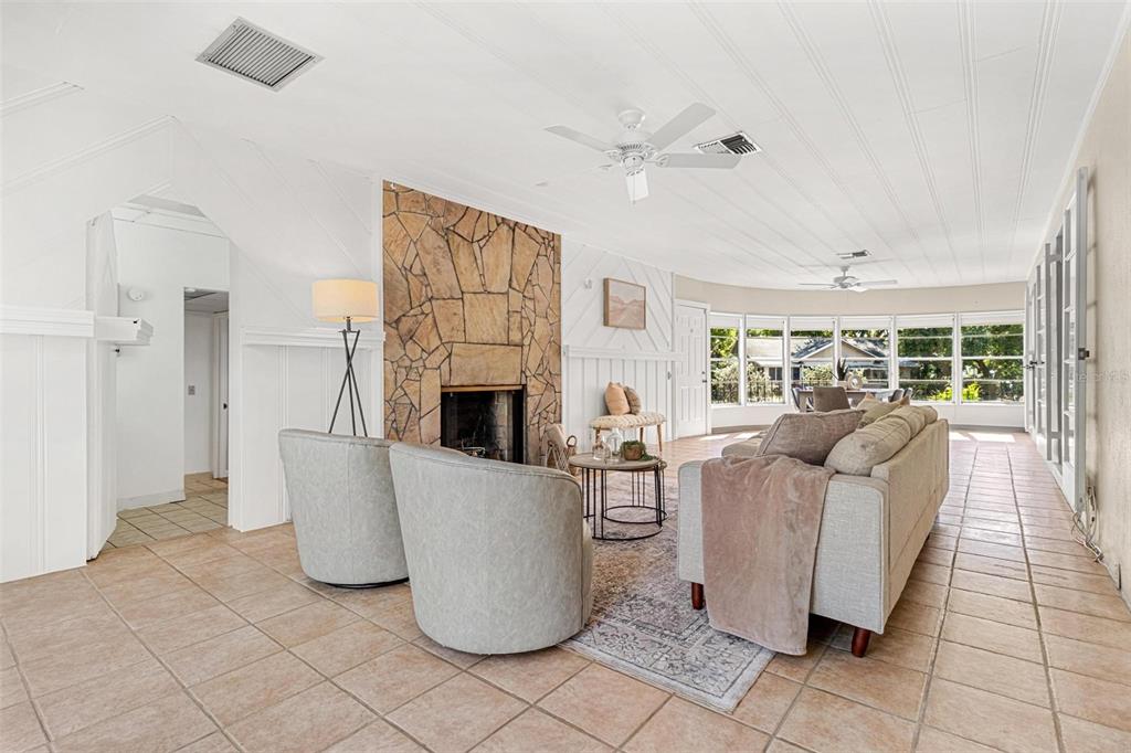 300 22nd Avenue South St. Petersburg, FL 33705 - Photo 33 of 82 a living room with furniture a fireplace and a floor to ceiling window