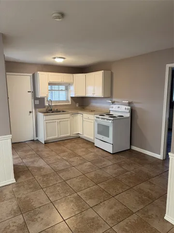 a kitchen with a stove top oven and cabinets