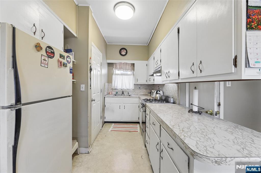 360 Rutherford Boulevard Clifton, NJ 07014 - Photo 14 of 42 a kitchen with a refrigerator a sink and cabinets
