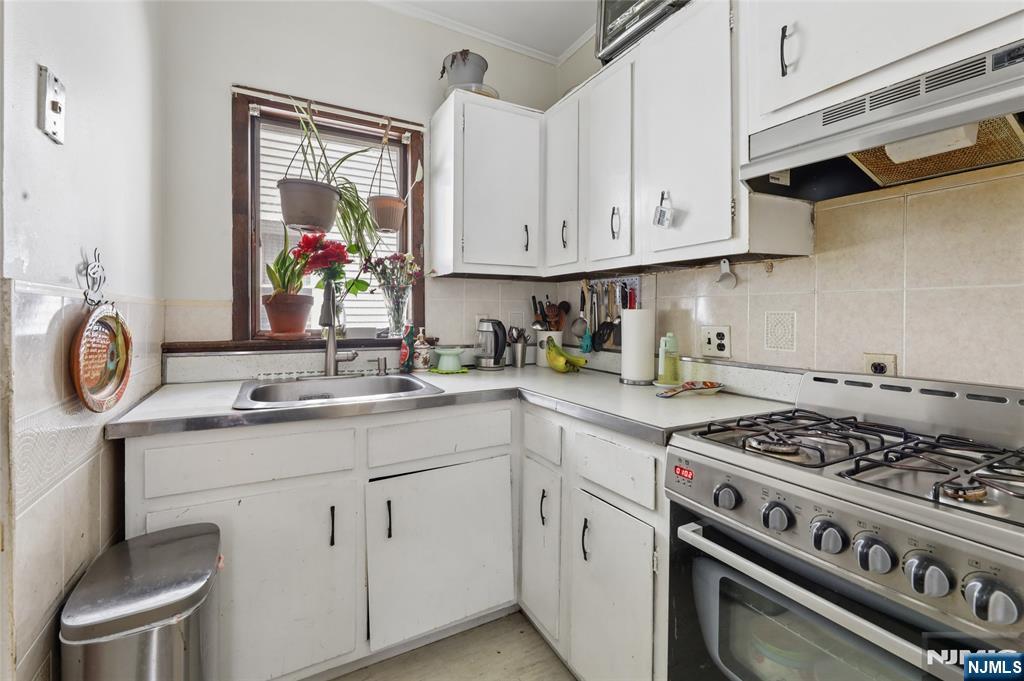 360 Rutherford Boulevard Clifton, NJ 07014 - Photo 10 of 42 a kitchen with white cabinets and appliances