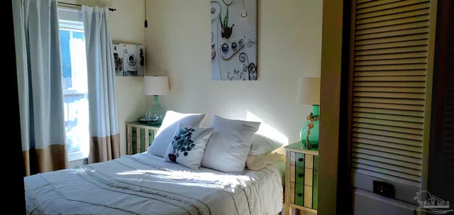 a bed sitting in a bedroom next to a bathroom