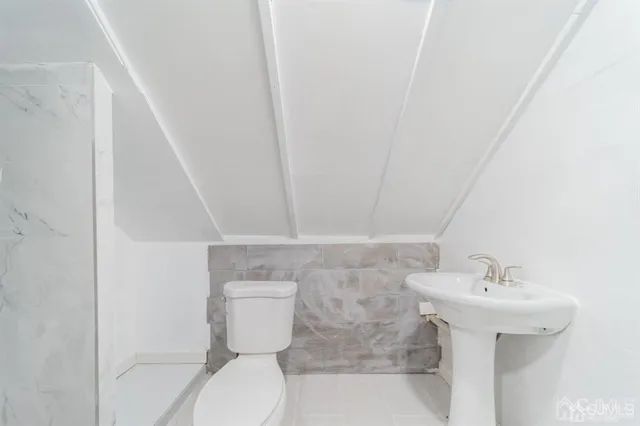 a bathroom with a sink toilet and a mirror