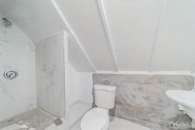 a white toilet sitting next to a shower
