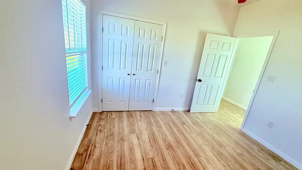 a view of an empty room with wooden floor