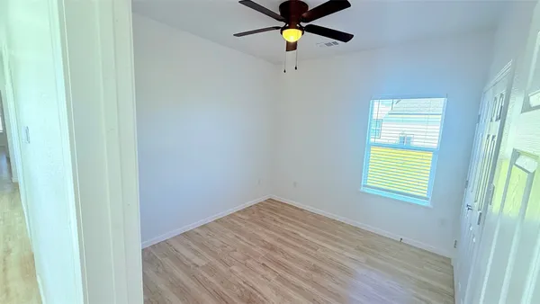 a view of empty room with wooden floor