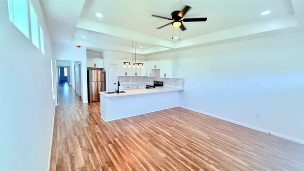 a view of a kitchen with a sink and wooden floor