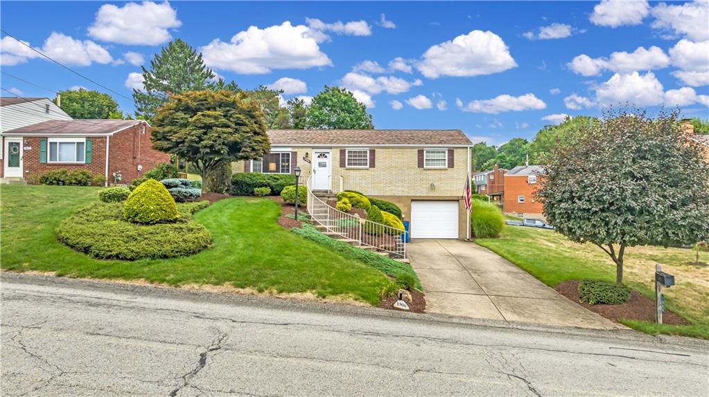 a front view of a house with a yard and potted plants