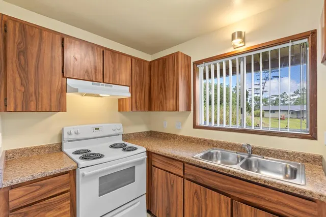 a kitchen with stainless steel appliances granite countertop wooden cabinets a sink and a window