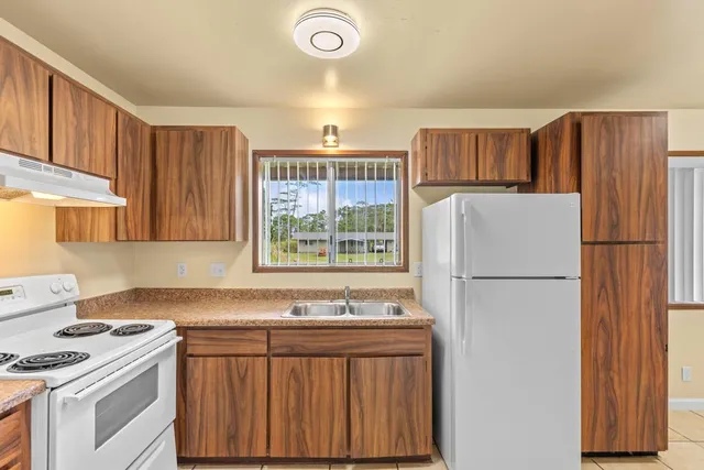 a kitchen with a refrigerator sink stove and cabinets