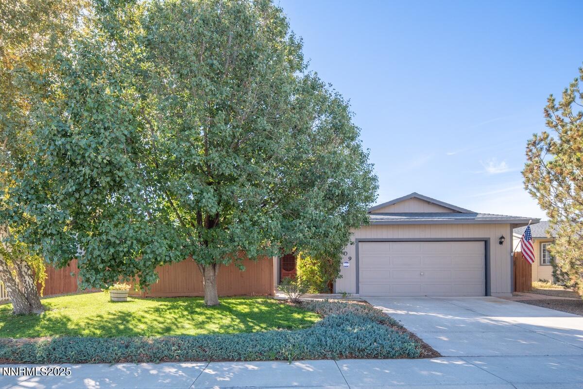a front view of a house with yard garage and outdoor seating