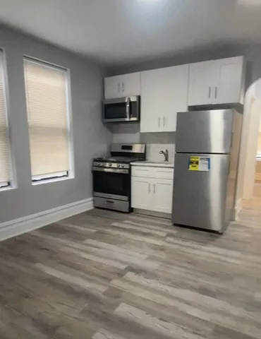 a kitchen with stainless steel appliances a refrigerator sink and white cabinets