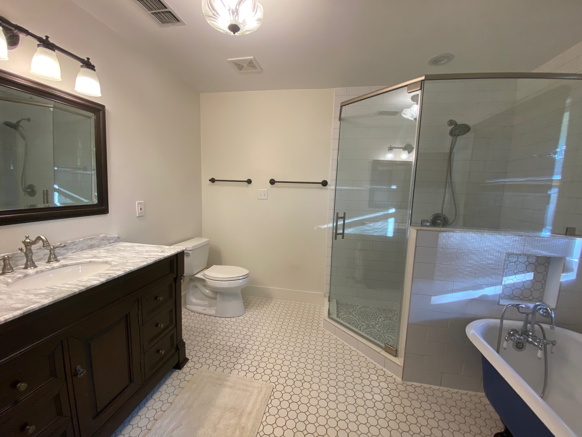 306 Plainview Road Wimberley, TX 78676 - Photo 12 of 29 A well-appointed bathroom offers a classic vanity, a spacious walk-in shower, and a charming freestanding tub.