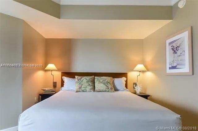 2889 McFarlane Road, Unit 1906 Miami, FL 33133 - Photo 4 of 9 a bedroom with a bed and a night stand