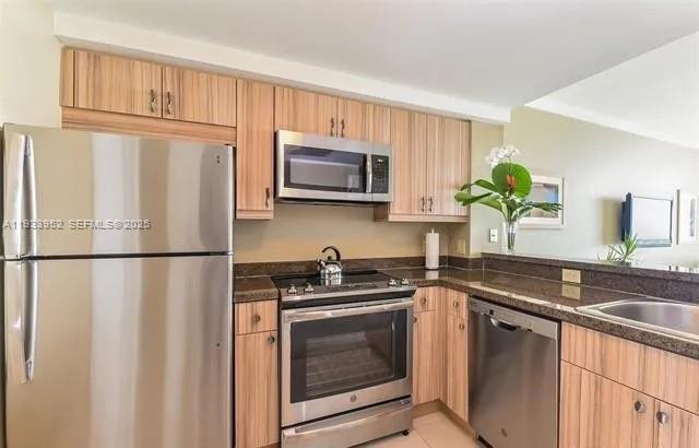 2889 McFarlane Road, Unit 1906 Miami, FL 33133 - Photo 6 of 9 a kitchen with granite countertop a refrigerator sink and microwave