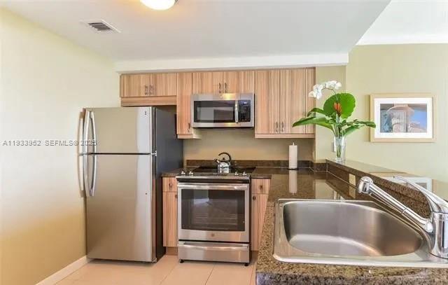 2889 McFarlane Road, Unit 1906 Miami, FL 33133 - Photo 9 of 9 a kitchen with a refrigerator sink and microwave
