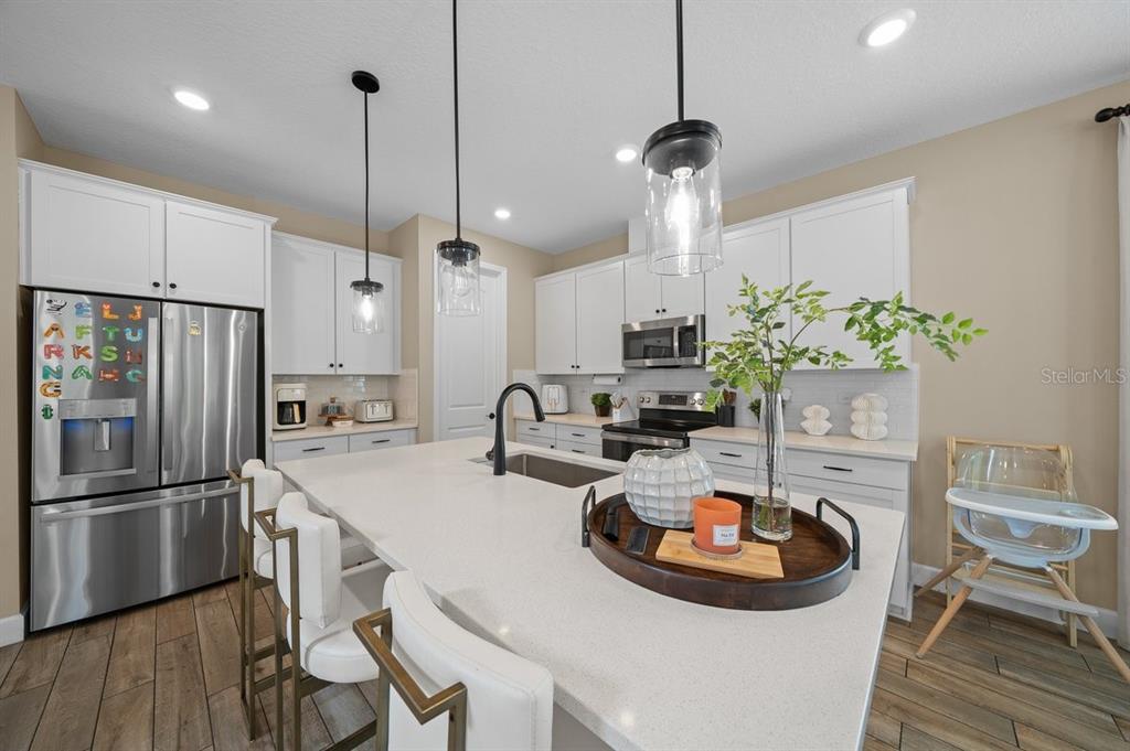 3916 Southern Vista Loop St. Cloud, FL 34772 - Photo 12 of 52 a kitchen with sink refrigerator and dining table