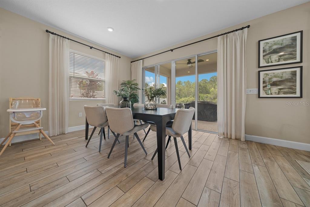3916 Southern Vista Loop St. Cloud, FL 34772 - Photo 18 of 52 a view of a dining room with furniture and wooden floor