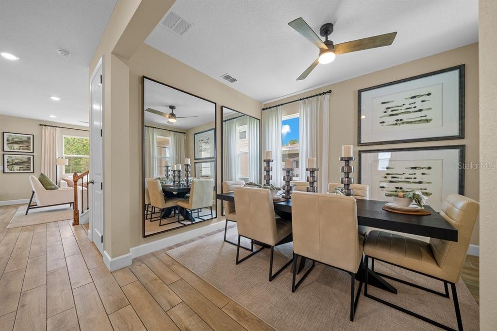 3916 Southern Vista Loop St. Cloud, FL 34772 - Photo 19 of 52 a dining room with wooden floor and a ceiling fan