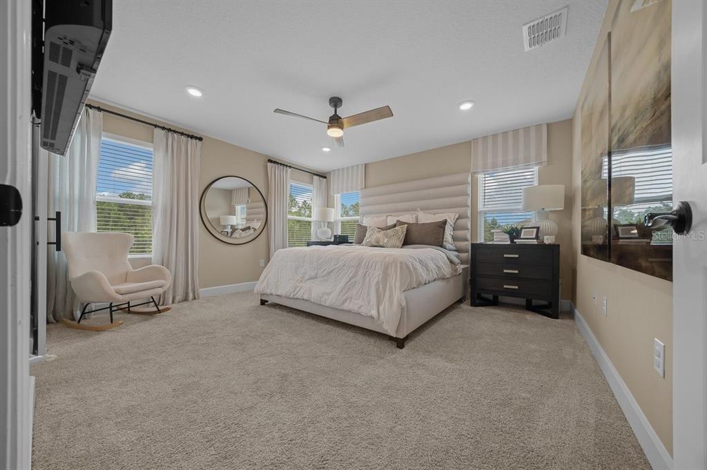 3916 Southern Vista Loop St. Cloud, FL 34772 - Photo 23 of 52 a spacious bedroom with a bed a mirror and a window