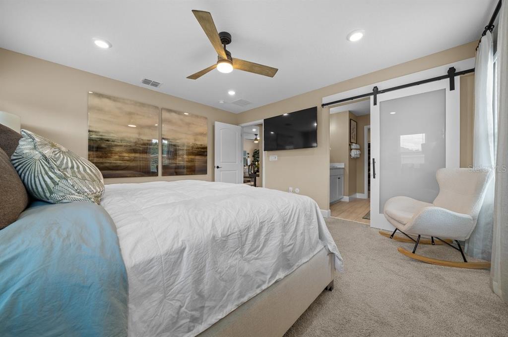 3916 Southern Vista Loop St. Cloud, FL 34772 - Photo 26 of 52 a spacious bedroom with a large bed and a large mirror