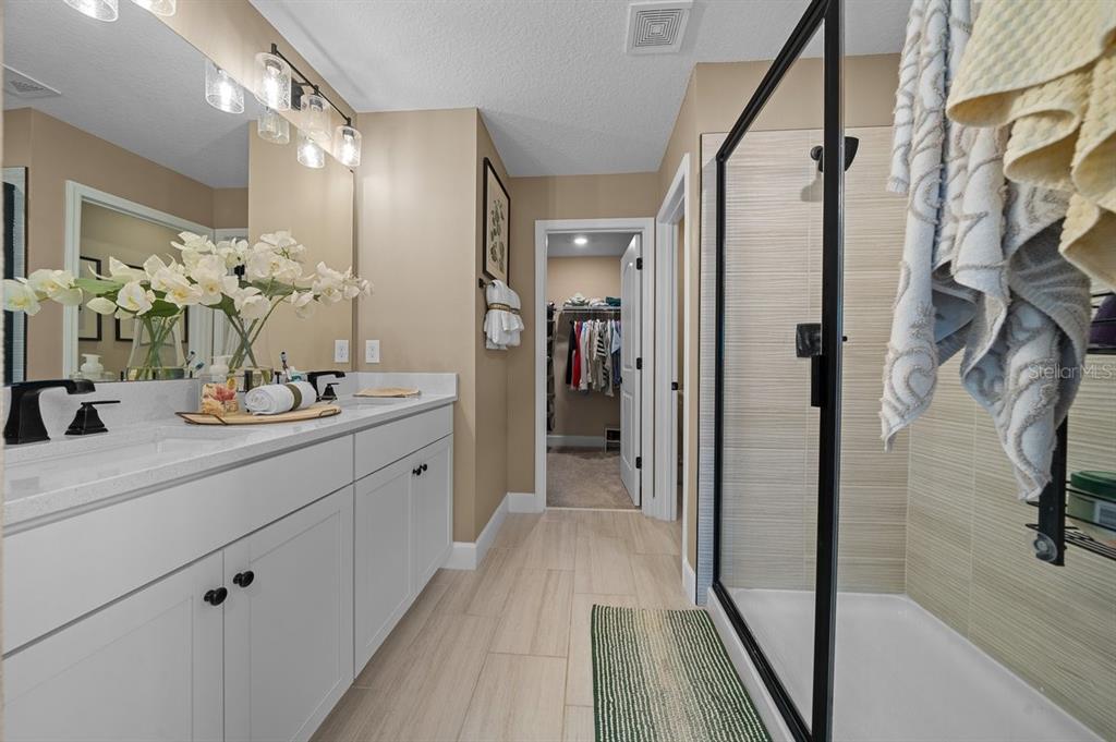 3916 Southern Vista Loop St. Cloud, FL 34772 - Photo 27 of 52 a spacious bathroom with a double vanity sink and a mirror