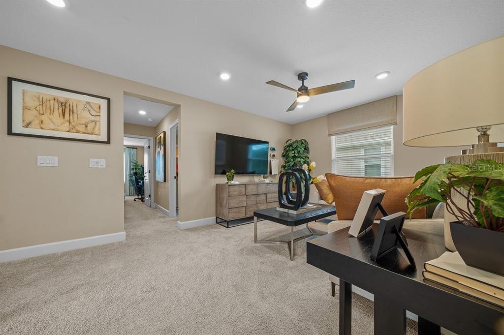 3916 Southern Vista Loop St. Cloud, FL 34772 - Photo 30 of 52 a living room with furniture a flat screen tv and a floor to ceiling window