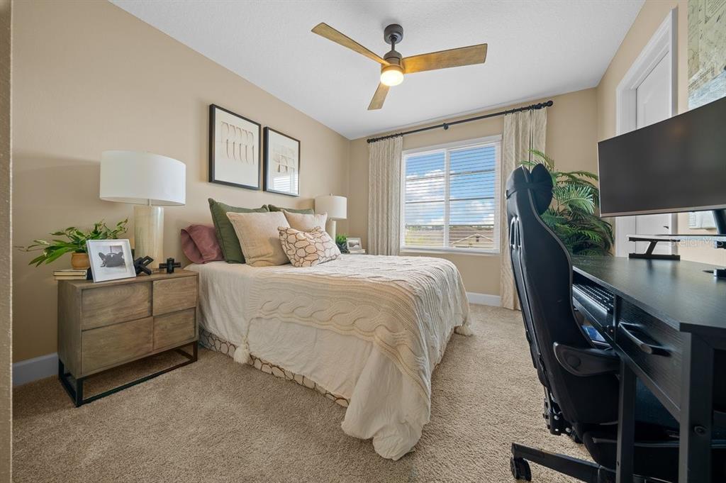 3916 Southern Vista Loop St. Cloud, FL 34772 - Photo 34 of 52 a bedroom with a bed furniture flat screen tv and a large window