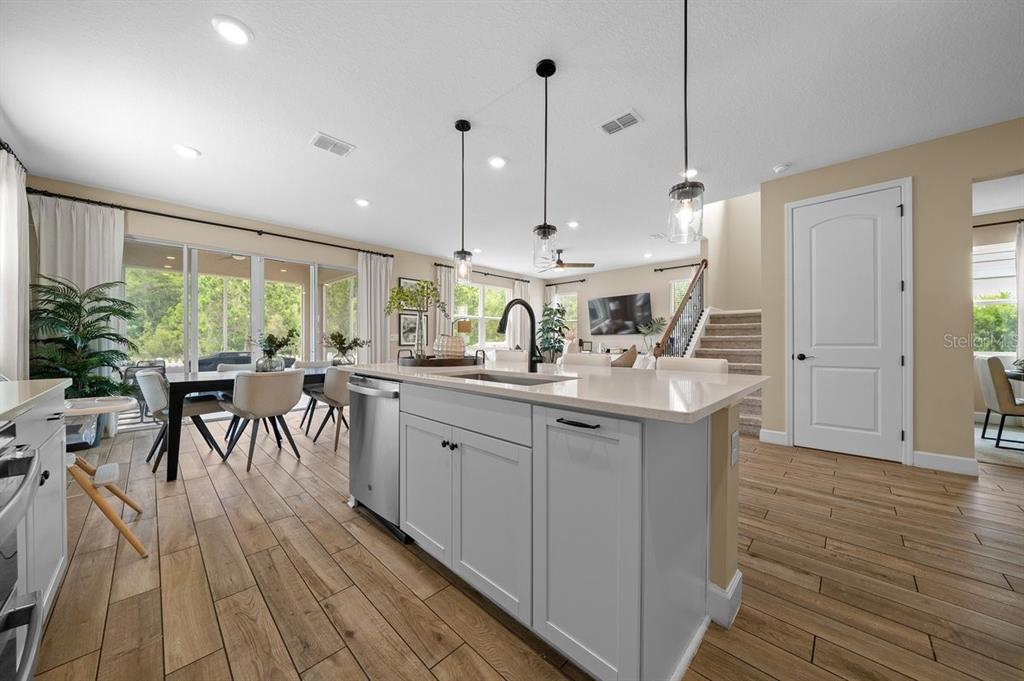 3916 Southern Vista Loop St. Cloud, FL 34772 - Photo 7 of 52 a kitchen with stainless steel appliances granite countertop a table chairs sink and stove top oven