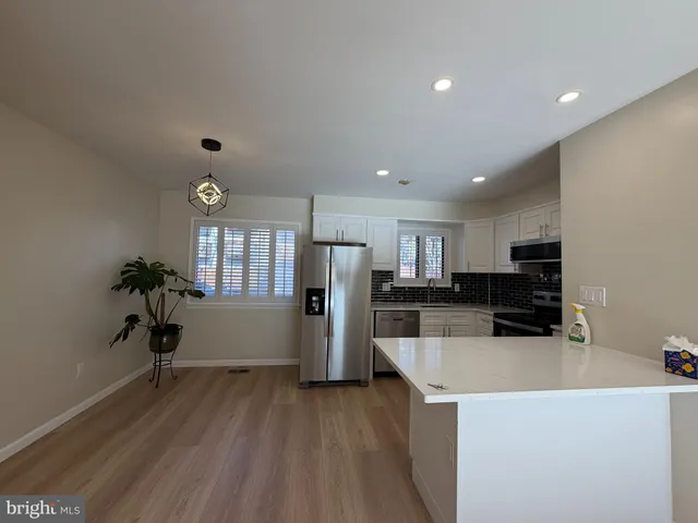 a kitchen with stainless steel appliances a refrigerator and a stove top oven