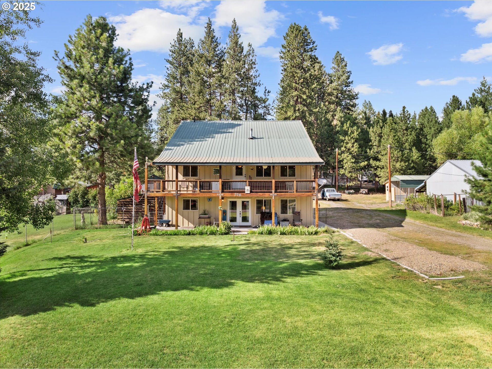 206 Austin Street Sumpter, OR 97877 - Photo 1 of 48 a view of a house with a big yard and large trees