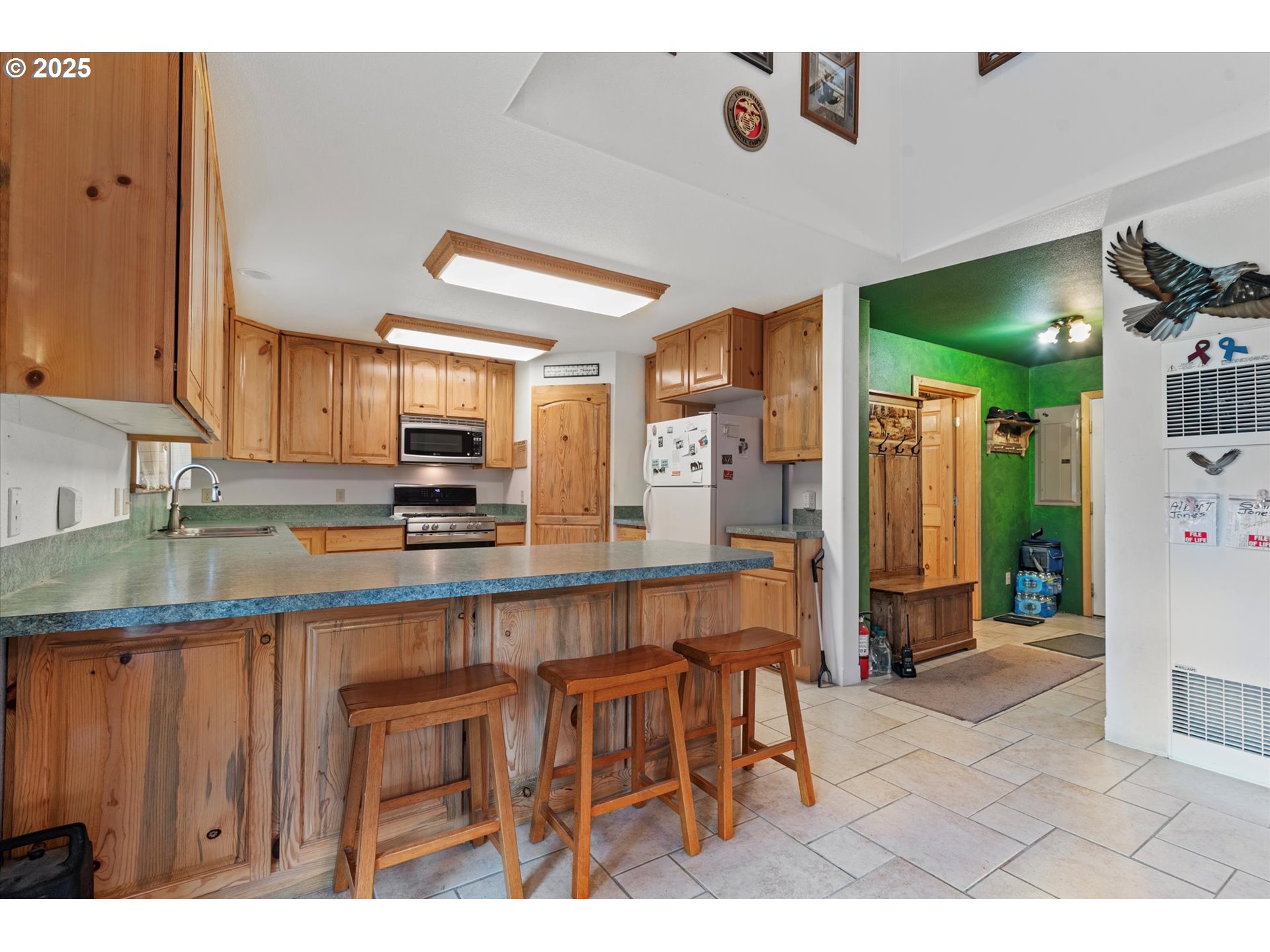 206 Austin Street Sumpter, OR 97877 - Photo 16 of 48 a kitchen with stainless steel appliances kitchen island granite countertop a refrigerator and microwave