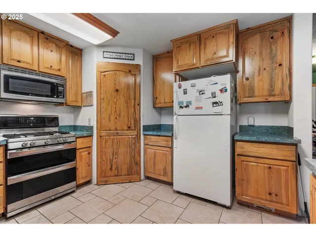 a kitchen with stainless steel appliances granite countertop a refrigerator stove and sink