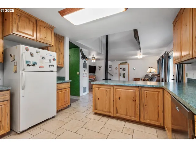 a kitchen with stainless steel appliances kitchen island granite countertop a refrigerator a stove and a sink