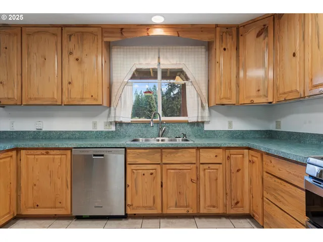 a kitchen with granite countertop a sink cabinets and stainless steel appliances