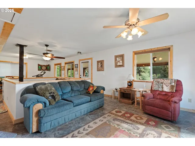 a living room with furniture ceiling fan and a window