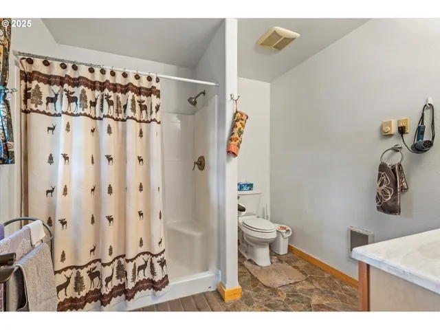 a bathroom with a toilet and a shower curtain