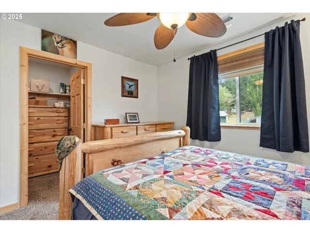 a bedroom with a bed and a dresser with wooden floor