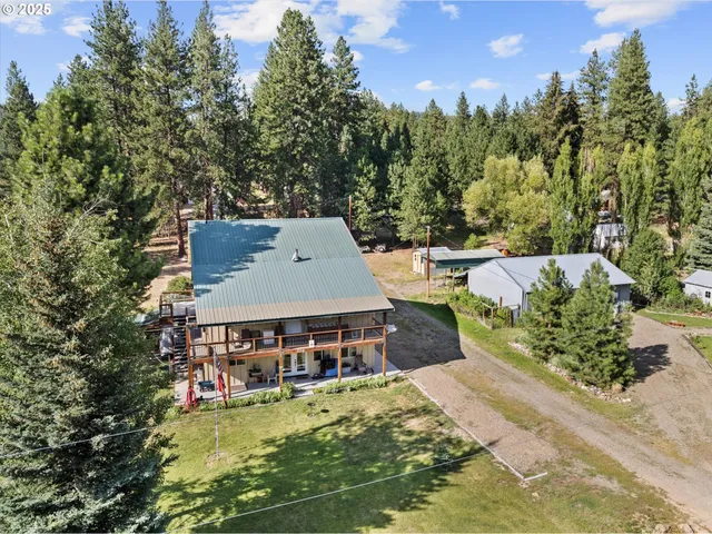 an aerial view of a house with swimming pool and tennis court